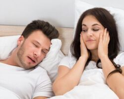 Husband sleeping on his bed with his wife